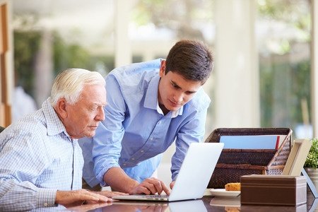 31067242 - teenage grandson helping grandfather with laptop