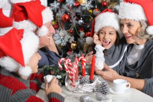 65629477 - portrait of happy grandparents with their grandchildren in santa hats celebrating christmas at home