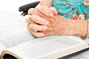 senior woman praying with bible